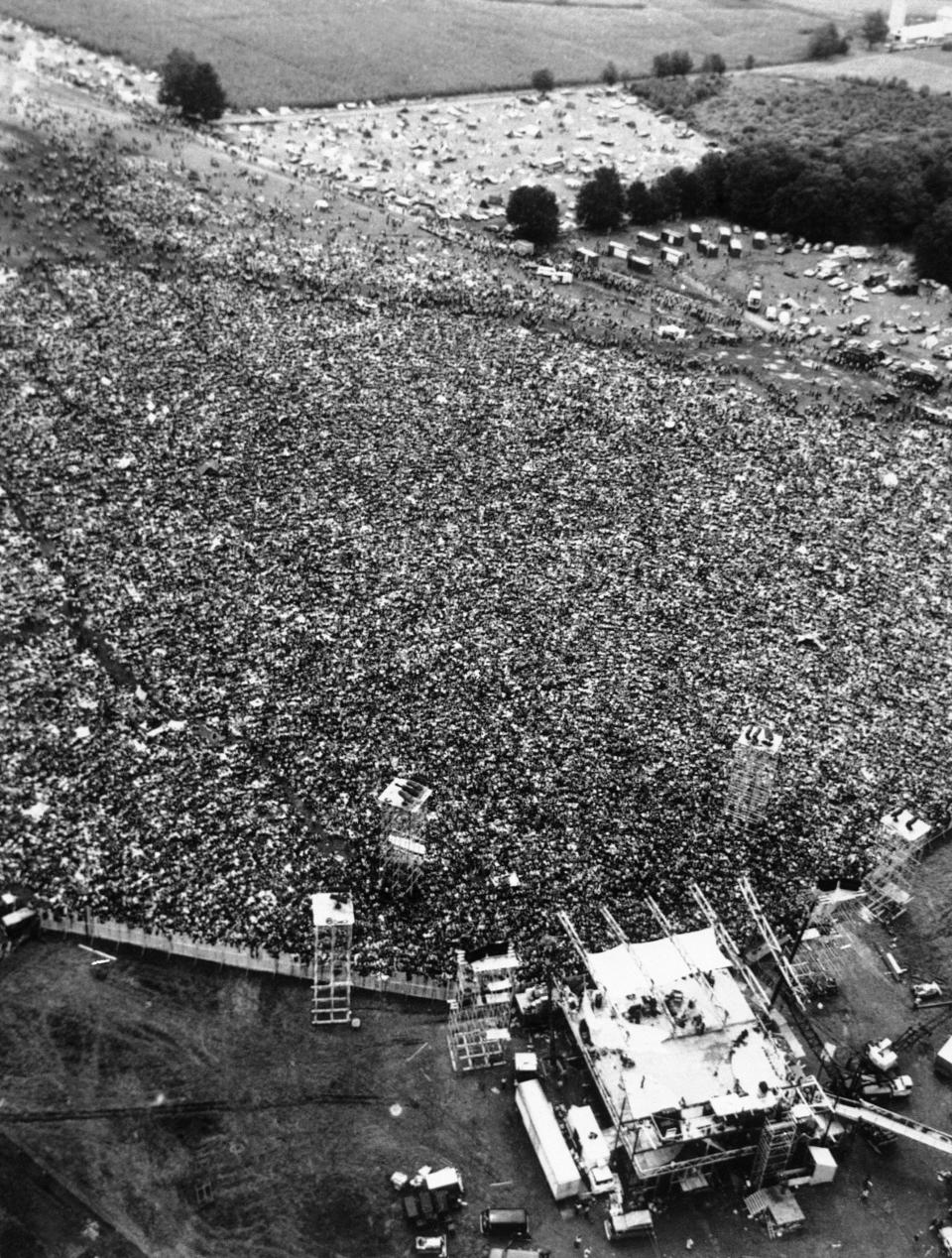 FILE - In this Aug. 16, 1969 file photo, thousands of rock music fans are packed around the stage in a field near Bethel, N.Y., at the Woodstock Festival. For the first time, an audio recording is available of nearly everything heard onstage at Woodstock 50 years ago - from transcendent music to announcements about lost people and bad acid. A 38-disc package "Woodstock - Back to the Garden - The Definitive Anniversary Archive" is available now. (AP Photo/Marty Lederhandler, File)