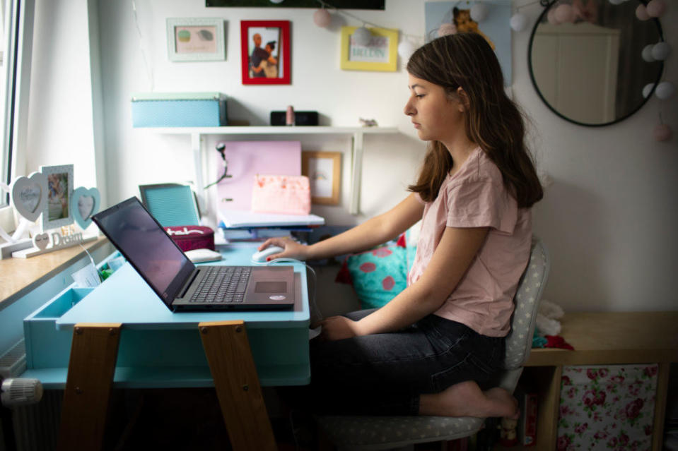 A modern teen works on a thin laptop