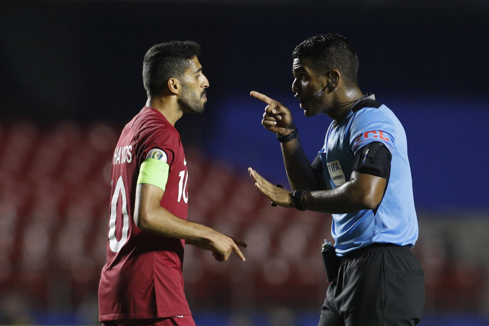 FILE - Referee Alexis Herrera, right, talks to Qatar's Hassan Al Haydos during a Copa America Group B soccer match at the Morumbi stadium in Sao Paulo, Brazil, Wednesday, June 19, 2019. (AP Photo/Victor R. Caivano)