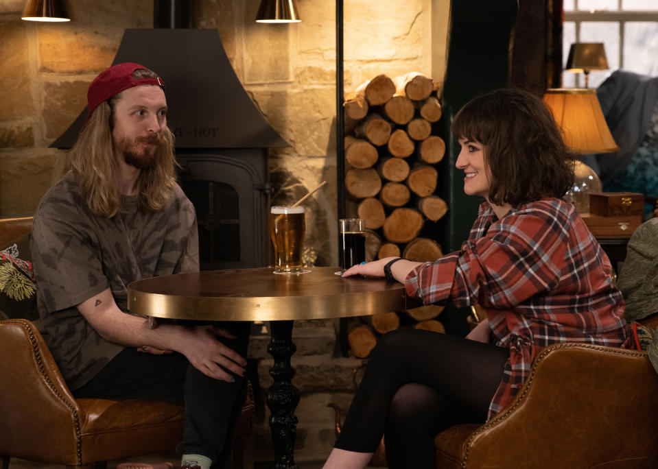 Ryan Stocks and Gail sit opposite each other with drinks on their table at The Woolpack.