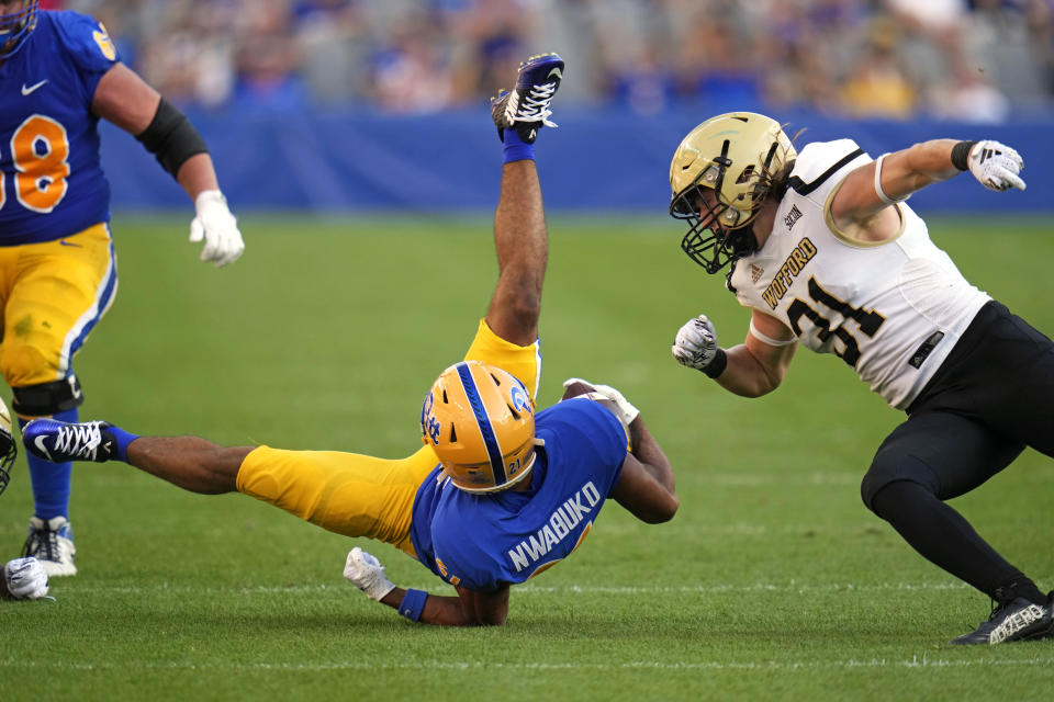 Pittsburgh wide receiver Che Nwabuko (21) is upended after catching a pass with Wofford linebacker Nick Morgan (31) defending during the second half of an NCAA college football game in Pittsburgh Saturday, Sept. 2, 2023. (AP Photo/Gene J. Puskar)