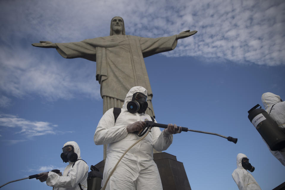 En esta imagen, tomada el 13 de agosto de 2020, soldados desinfectan las inmediaciones del Cristo Redentor, que está cerrado al público, para prepararlo para lo que las autoridades de turismo esperan que sea una ola de visitantes el próximo fin de semana ante el alivio de las restricciones contra el coronavirus, en Río de Janeiro, Brasil. (AP Foto/Silvia Izquierdo)