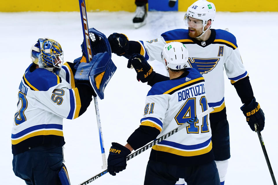 St. Louis Blues goaltender Jordan Binnington (50) celebrates the team's 5-4 overtime win against the Arizona Coyotes with defensemen Robert Bortuzzo (41) and Colton Parayko (55), after an NHL hockey game Saturday, April 23, 2022, in Glendale, Ariz. (AP Photo/Ross D. Franklin)