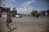 Policemen and paramilitary soldiers patrol a road during curfew in Srinagar, Indian controlled Kashmir, Tuesday, Aug. 4, 2020. Authorities clamped a curfew in many parts of Indian-controlled Kashmir on Tuesday, a day ahead of the first anniversary of India’s controversial decision to revoke the disputed region’s semi-autonomy. Shahid Iqbal Choudhary, a civil administrator, said the security lockdown was clamped in the region’s main city of Srinagar in view of information about protests planned by anti-India groups to mark Aug. 5 as “black day." (AP Photo/Mukhtar Khan)