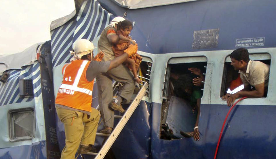 Rescuers evacuate an injured child from the site of a train accident at a station near Penukonda, about 170 kilometers (105 miles) north of Bangalore, India, Tuesday, May 22, 2012. The passenger train rammed into a parked freight train and burst into flames before dawn Tuesday, killing more than a dozen people in southern India, officials said. (AP Photo)