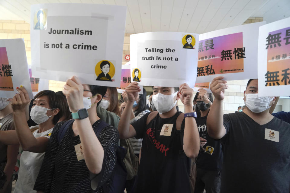 Supporters of Hong Kong journalist Choy Yuk-ling, chant placards outside a court in Hong Kong Thursday, April 22, 2021. A Hong Kong journalist was fined 6,000 Hong Kong dollars ($775) on Thursday after being found guilty of making false statements while obtaining information from a vehicle database, in the latest blow to press freedom in the city as authorities continue their crackdown on dissent. (AP Photo/Kin Cheung)