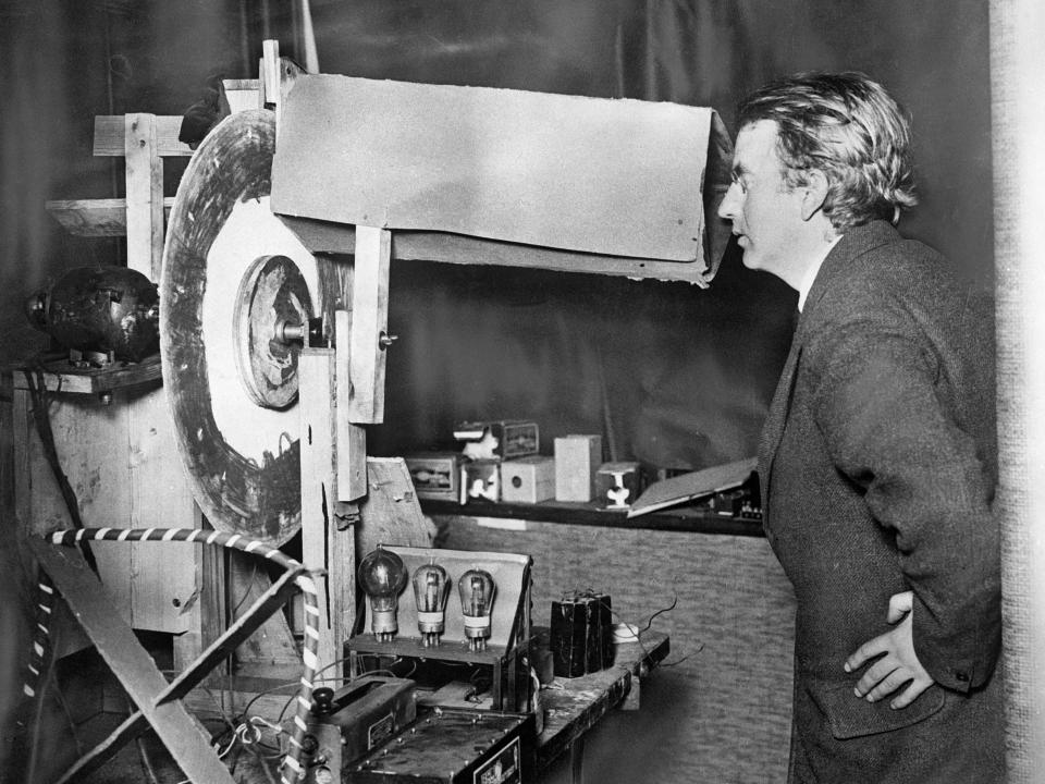 John Logie Baird looking into a large mechanical television.