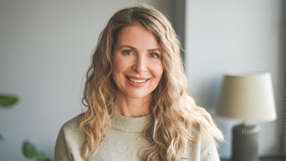 A blonde woman with a white smile and healthy teeth who use mouthwash