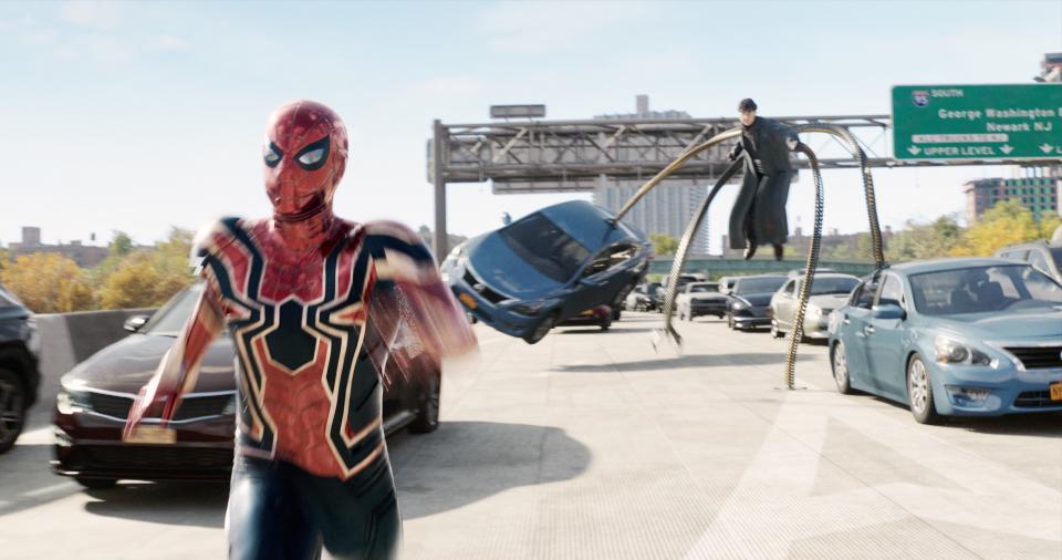 Spider-Man is chased by Alfred Molina as Doctor Octopus on a highway