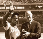 FILE - In this April 4, 1974, file photo, baseball commissioner Bowie Kuhn, right, presents Atlanta Braves' Hank Aaron with a trophy after he tied Babe Ruth's all-time home run record in Cincinnati. (AP Photo/Bob Johnson, File)