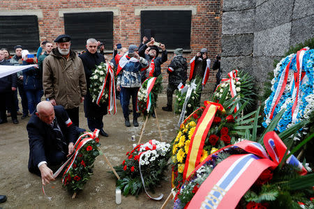 Piotr Rybak of the Polish independence movement and other far right activists lay wreaths at the "death wall" to pay tribute to Polish victims, during the ceremonies marking the 74th anniversary of the liberation of the camp and International Holocaust Victims Remembrance Day, in Oswiecim, Poland, January 27, 2019. REUTERS/Kacper Pempel