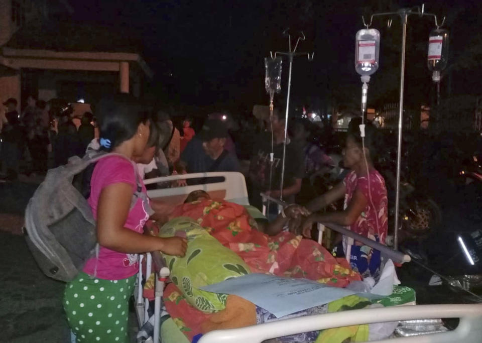 Patients are evacuated from a hospital following a strong earthquake in Poso, central Sulawesi, Indonesia, Friday, Sept. 28, 2018. Powerful earthquakes jolted the Indonesian island of Sulawesi on Friday, damaging houses and briefly triggered a tsunami warning. (AP Photo/Yoanes Litha)