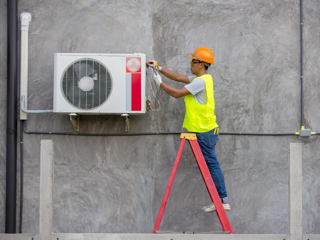 Air condition technician service checking air conditioner on the wall building