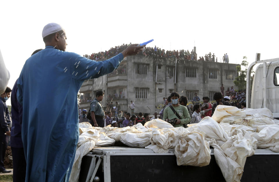 A Bangladeshi Muslim man sprays holy water before burying the bodies of some of the victims of Saturday's fire in a garment factory in Dhaka, Bangladesh, Tuesday, Nov. 27, 2012. Bangladesh held a day of mourning Tuesday for the 112 people killed in a weekend fire at a garment factory, and labor groups planned more protests to demand better worker safety in an industry notorious for operating in firetraps. (AP Photo/Ashraful Alam Tito)