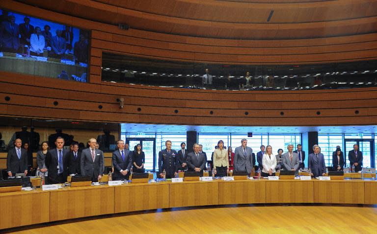 Foreign ministers of several countries stand for a minute of silence before the start of an emergency meeting of foreign and interior ministers in Luxembourg on April 20, 2015