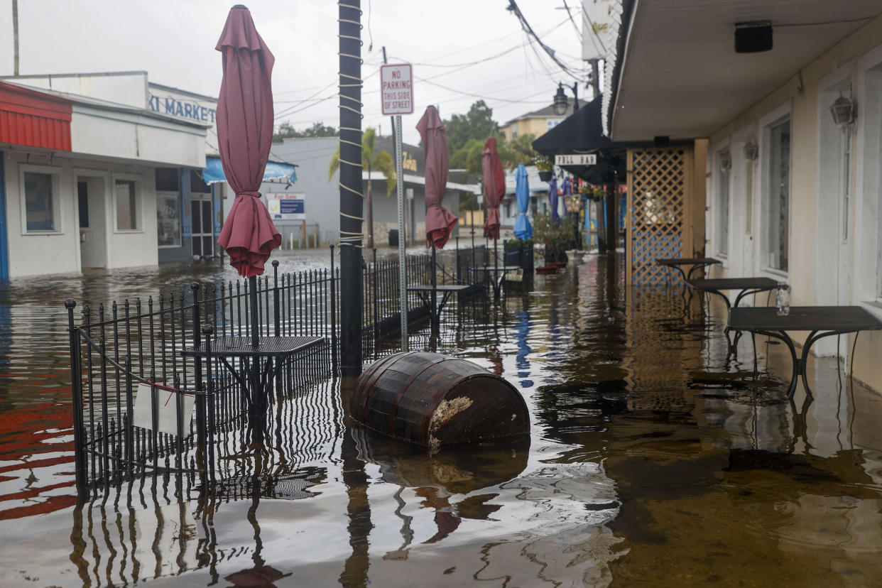 A flooded street and outdoor restaurant seating area.