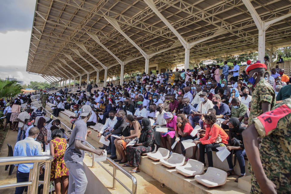 People wait in the stands to receive coronavirus vaccinations at the Kololo airstrip in Kampala, Uganda, Monday, May 31, 2021. As virus cases surge in the world's poorest countries, a sense of dread is growing among millions of the unvaccinated, especially those who toil in the informal, off-the-books economy, live hand-to-mouth and pay cash in health emergencies. (AP Photo/Nicholas Bamulanzeki)