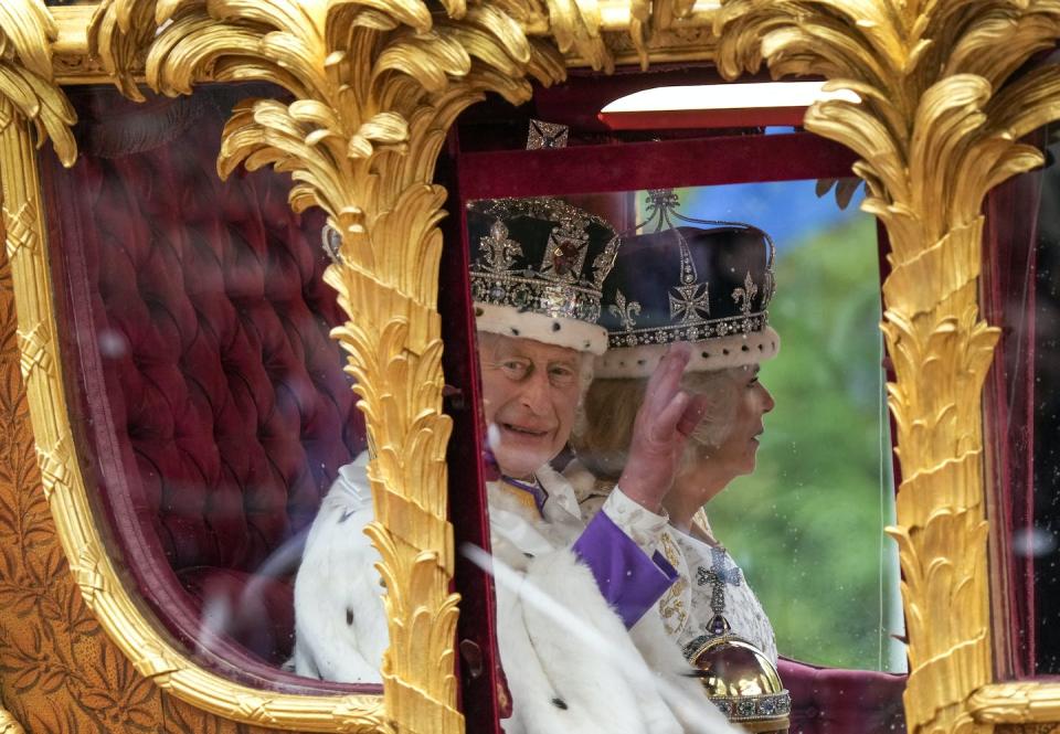 King Charles waves from a golden carriage following his coronation in London on May 6, 2023. THE CANADIAN PRESS/Nathan Denette