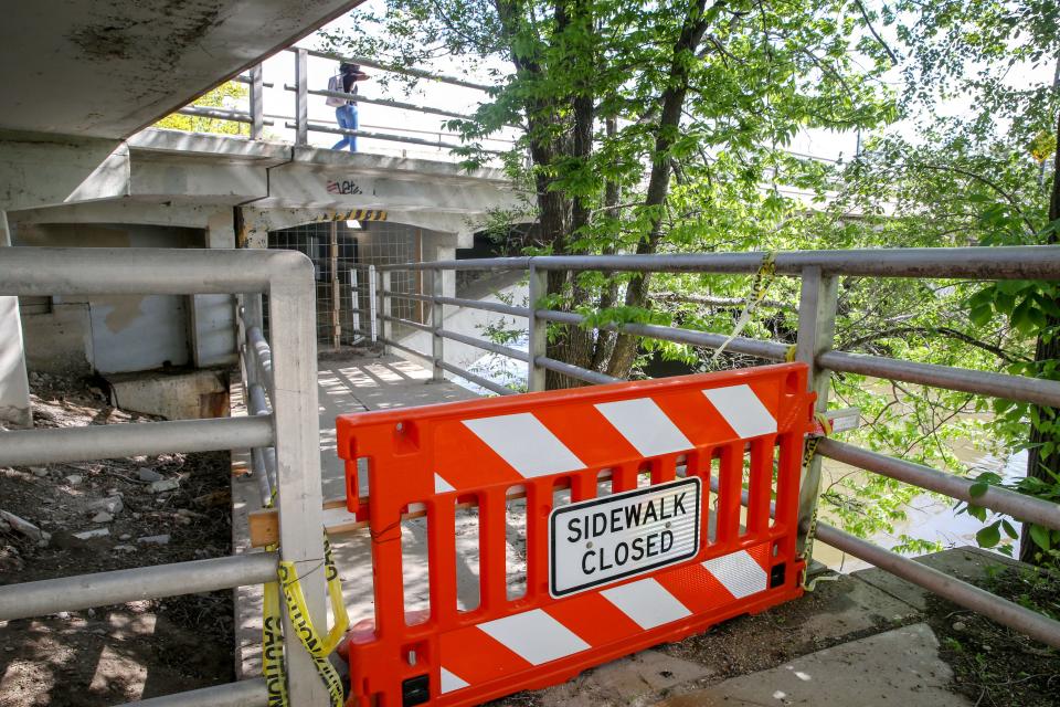 A sign signals the closure of the pedestrian tunnel under the Iowa Avenue bridge in Iowa City.