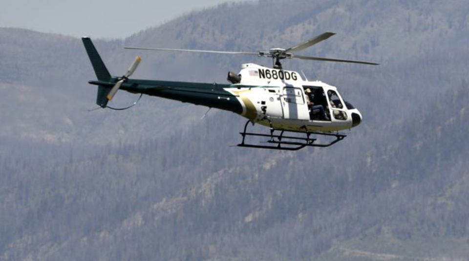 A helicopter from Montana Fish, Wildlife and Parks flies around the Ovando, Mont., area in search of a bear that killed a camper early that morning. Source: Tom Bauer/The Missoulian via AP
