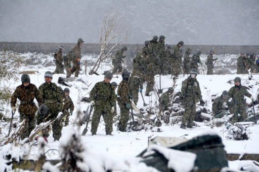 Japan's Self Defence Force soldiers search for missing people in a snow covered field in Miyako in Iwate prefecture on Wednesday