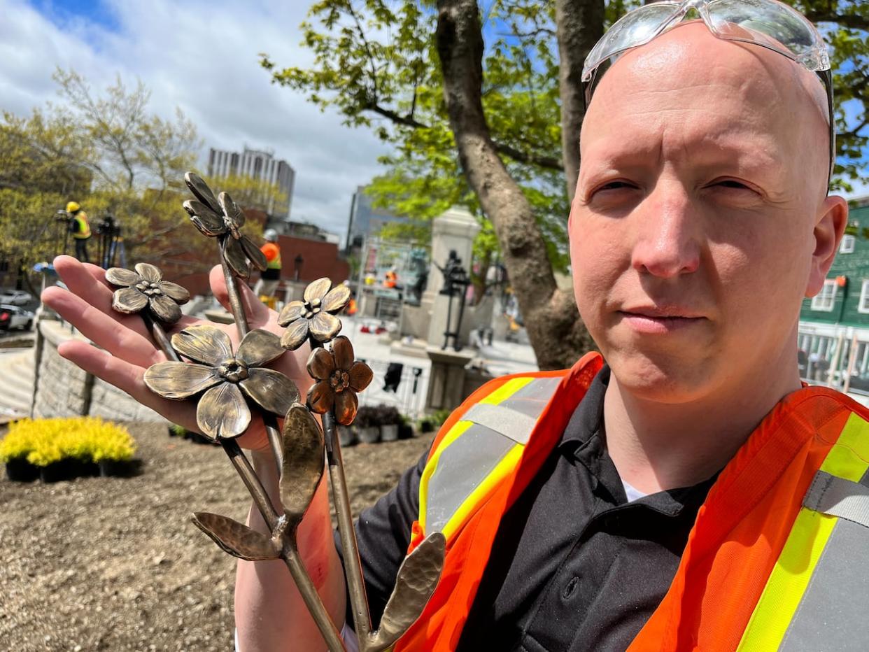 St. John's artist Morgan MacDonald has been contracted by the provincial government to freshen up the five bronze statues that dominate the Newfoundland National War Memorial in St. John's. He's also creating a bronze bouquet of forget-me-not flowers that will decorate the cover of the new tomb of the unknown soldier. (Terry Roberts/CBC - image credit)