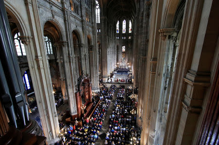 People attend Easter Sunday Mass at Saint-Eustache, days after a massive fire devastated large parts of the structure of the gothic Notre-Dame Cathedral, in Paris, France, April 21, 2019. REUTERS/Gonzalo Fuentes