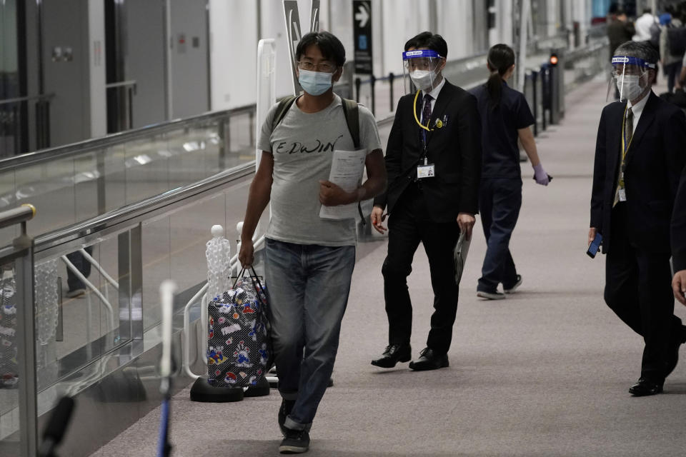 Yuki Kitazumi, a Japanese freelance journalist detained by security forces in Myanmar in mid-April and accused of spreading fake news criticizing the military coup, walks as he arrives at Narita International Airport, in Narita, east of Tokyo. (AP Photo/Eugene Hoshiko)