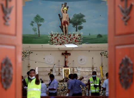 Police officers work at the scene at St. Sebastian Catholic Church, after bomb blasts ripped through churches and luxury hotels on Easter, in Negombo, Sri Lanka April 22, 2019. REUTERS/Athit Perawongmetha TPX IMAGES OF THE DAY