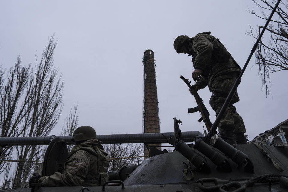 A Ukrainian marine serviceman stands atop on the APC before getting into position, in the frontline city of Vuhledar, Ukraine, Saturday, Feb. 25, 2023. (AP Photo/Evgeniy Maloletka)