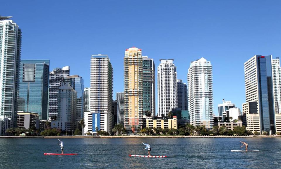 More condo terminations are on the rise. As a result, real estate analysts and lawyers predict South Florida’s skyline will change. Above: People ride paddle boards past Brickell, the county’s financial district. PATRICK FARRELL/MIAMI HERALD