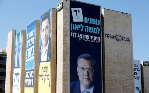 Moshe Lion (right poster) is facing Ofer Berkovtch (left poster) in Tuesday's election - Credit: REUTERS/Ronen Zvulun