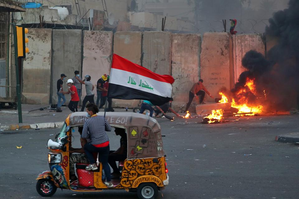 Anti-government protests set fire while security forces fired live ammunition and tear gas near the state-run TV in Baghdad, Iraq, Monday, Nov. 4, 2019. (AP Photo/Khalid Mohammed)