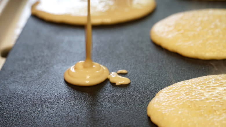 Pancakes being poured onto electric griddle