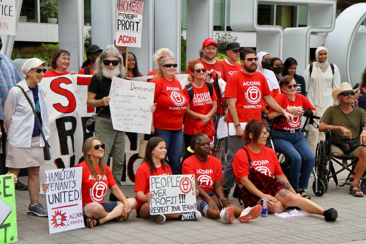 Tenants with ACORN held a rally outside Hamilton city hall on Aug. 17, 2023, demanding councillors strengthen the proposed renoviction bylaw.  (Samantha Beattie/CBC - image credit)