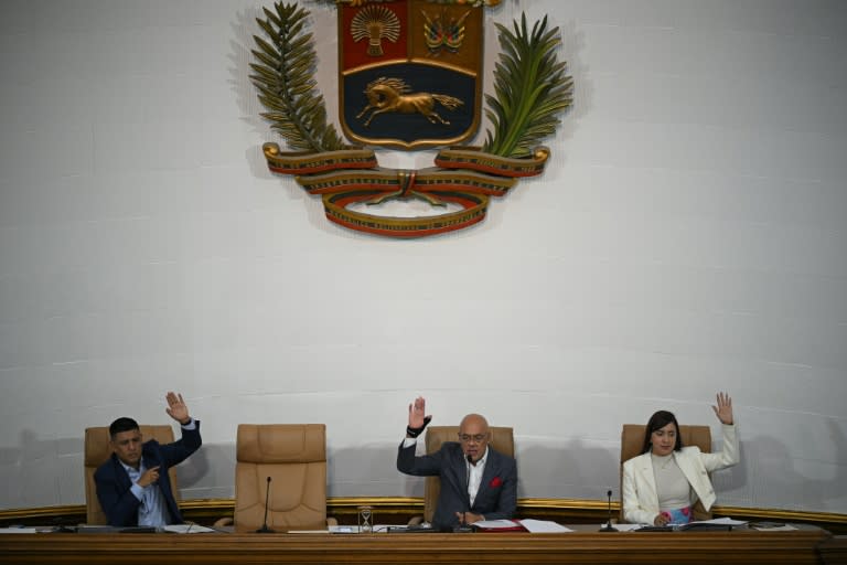 El presidente del Parlamento de Venezuela, Jorge Rodríguez (Centro), el primer vicepresidente, Pedro Infante, y la segunda vicepresidenta, América Pérez, votan durante una sesión para presentar una ley pensiones en Caracas el 2 de mayo de 2024 (Federico PARRA)