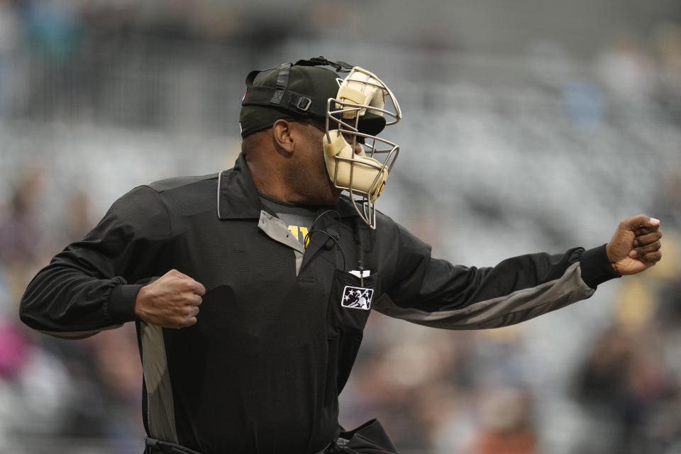 An umpire signals for a strikeout after being told a strike call through an earpiece during the first inning of a minor league baseball game between the St. Paul Saints and the Nashville Sounds, Friday, May 5, 2023, in St. Paul, Minn. Automatic balls and strikes could soon be coming to the major leagues. Much like the players themselves, robo-umps are working their way up through the minors with the goal being promoted to the show. (AP Photo/Abbie Parr)