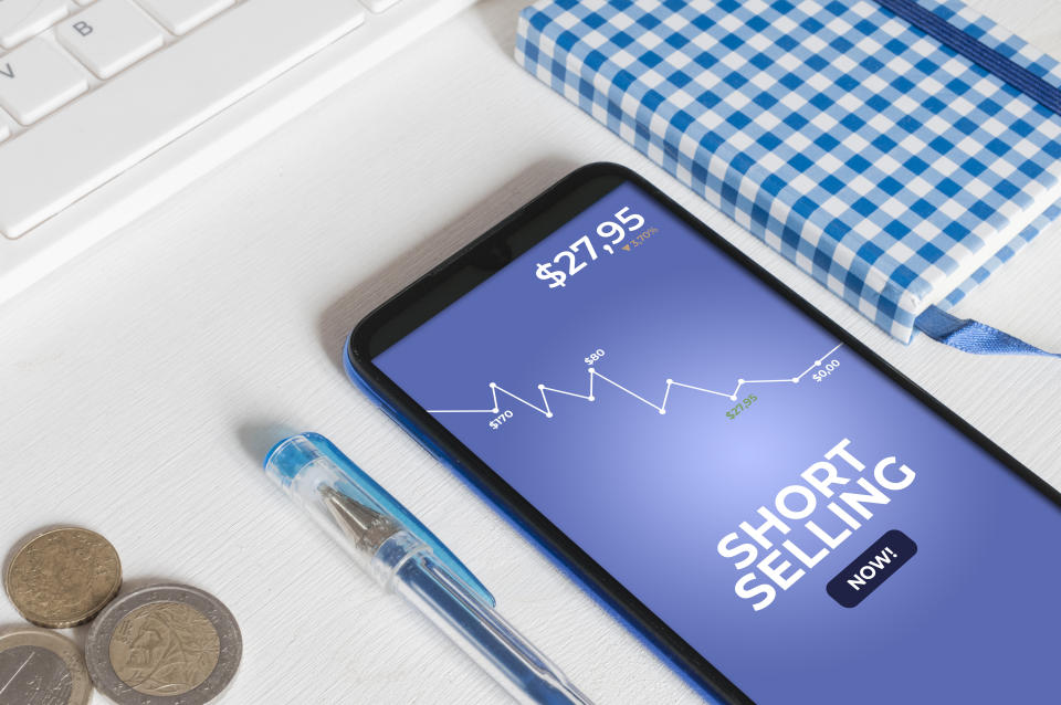 Short selling concept: smartphone on a white wooden table showing an app to trade stock option with the message 