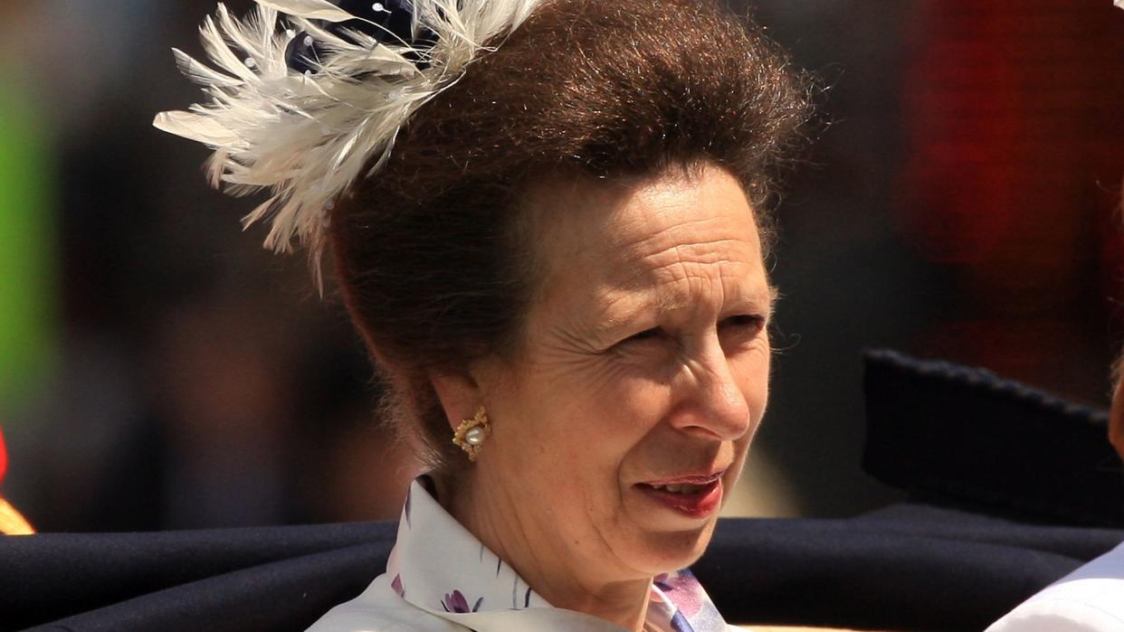 Princess Anne in a white jacket and feathered hair accessory