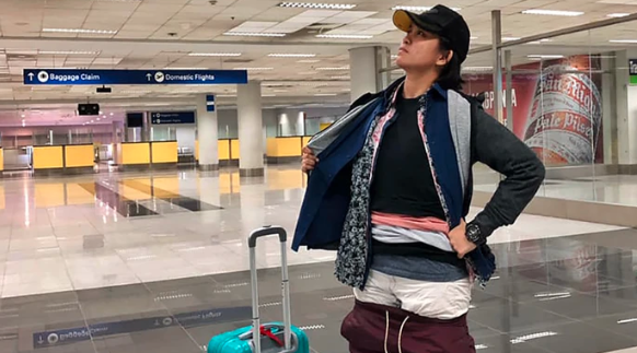 Gel Rodriguez at the airport with layers of her hand luggage clothes on