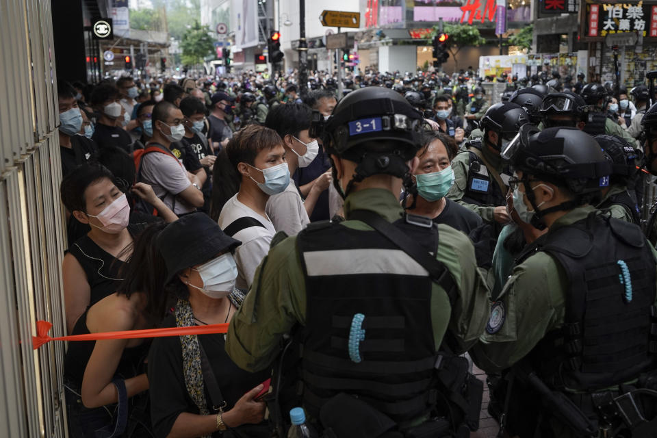 Police check pedestrians during China's National Day in Causeway Bay, Hong Kong, Thursday, Oct. 1, 2020. A popular shopping district in Causeway Bay saw a heavy police presence after online calls urged people to join protests. (AP Photo/Kin Cheung)