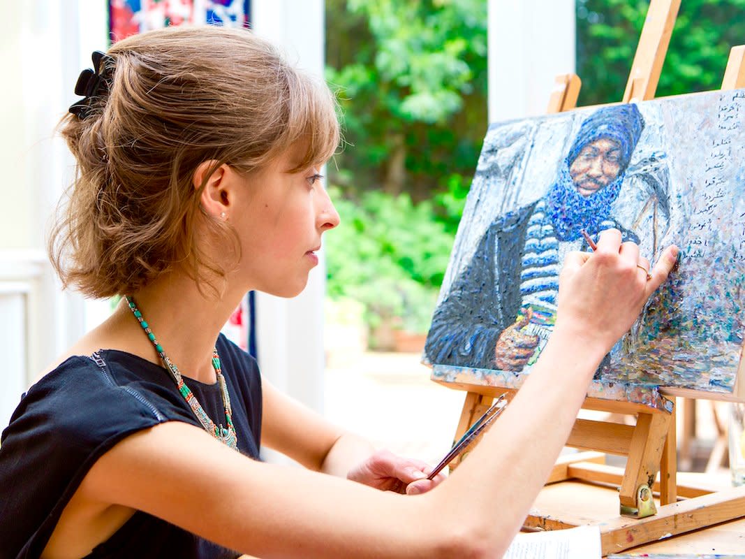 Hannah Rose Thomas painting a portrait of a refugee.