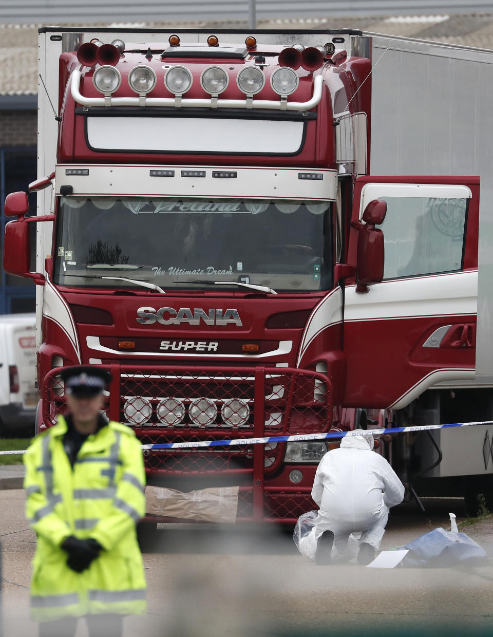 Police forensic officers attend the scene after a truck was found to contain a large number of dead bodies, in Thurrock, South England, Wednesday Oct. 23, 2019. Police in southeastern England said that 39 people were found dead Wednesday inside a truck container believed to have come from Bulgaria. (AP Photo/Alastair Grant)