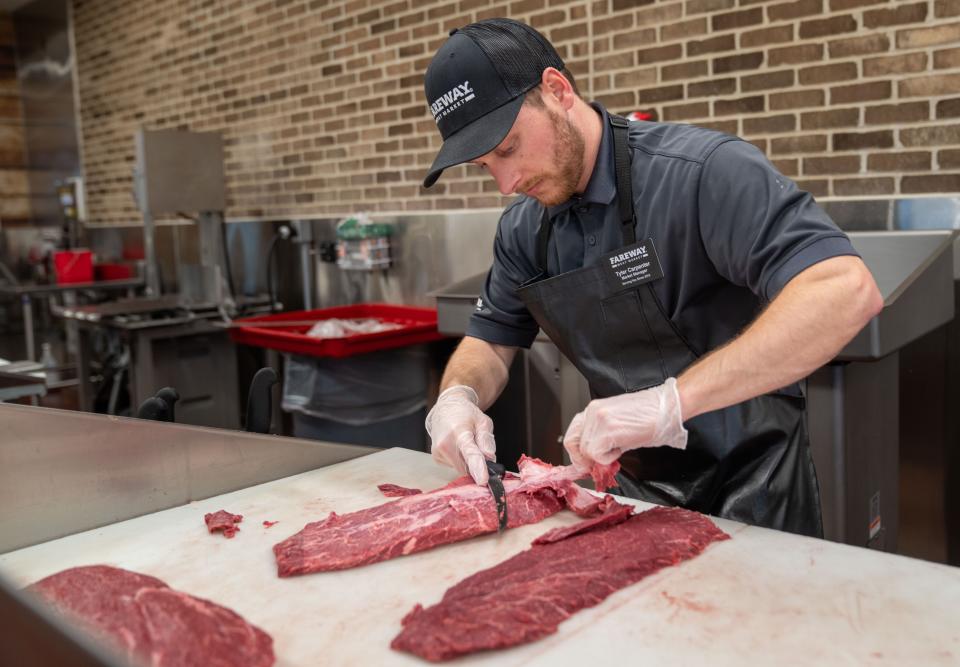 Tyler Carpenter, manager of the Fareway Meat Market, trims a flat iron steak at his store in Ames, Wednesday, Jan. 4, 2023.