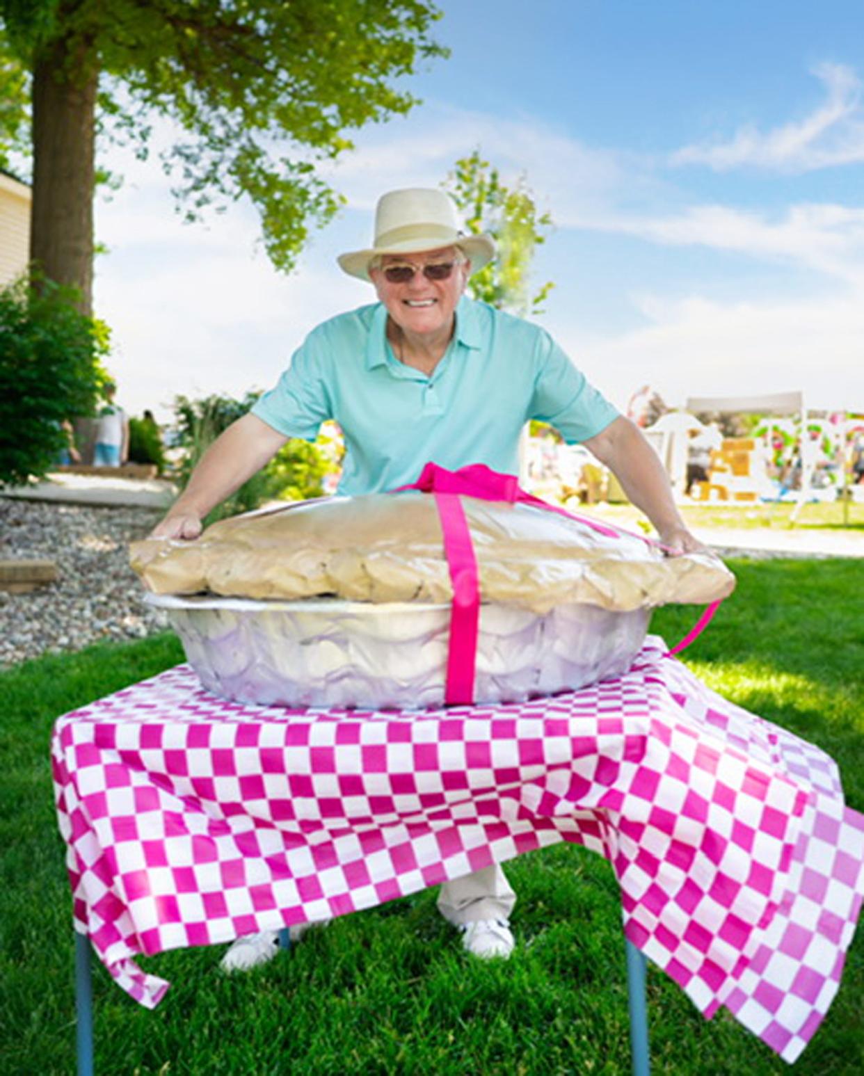 Aledo resident Don Greer poses by a rhubarb pie sculpture created for the 30th anniversary of the Rhubarb Fest.