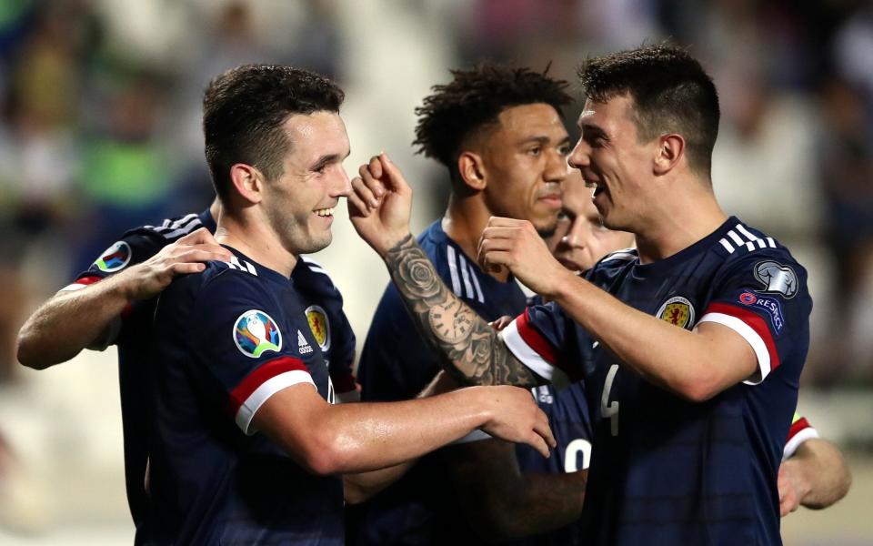 John McGinn (left) celebrates scoring his fifth goal in five matches for Scotland - PA