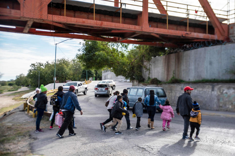 A group of migrants cross the street (Sergio Flores / AFP via Getty Images file)