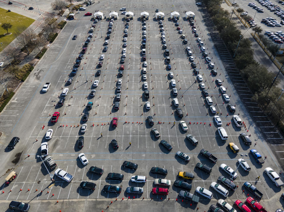 Cars line up in a parking lot at NRG Park as people wait to receive a COVID-19 vaccine at a federally supported supersite at the Harris County facility, Wednesday, Feb. 24, 2021, in Houston. ( Mark Mulligan/Houston Chronicle via AP)