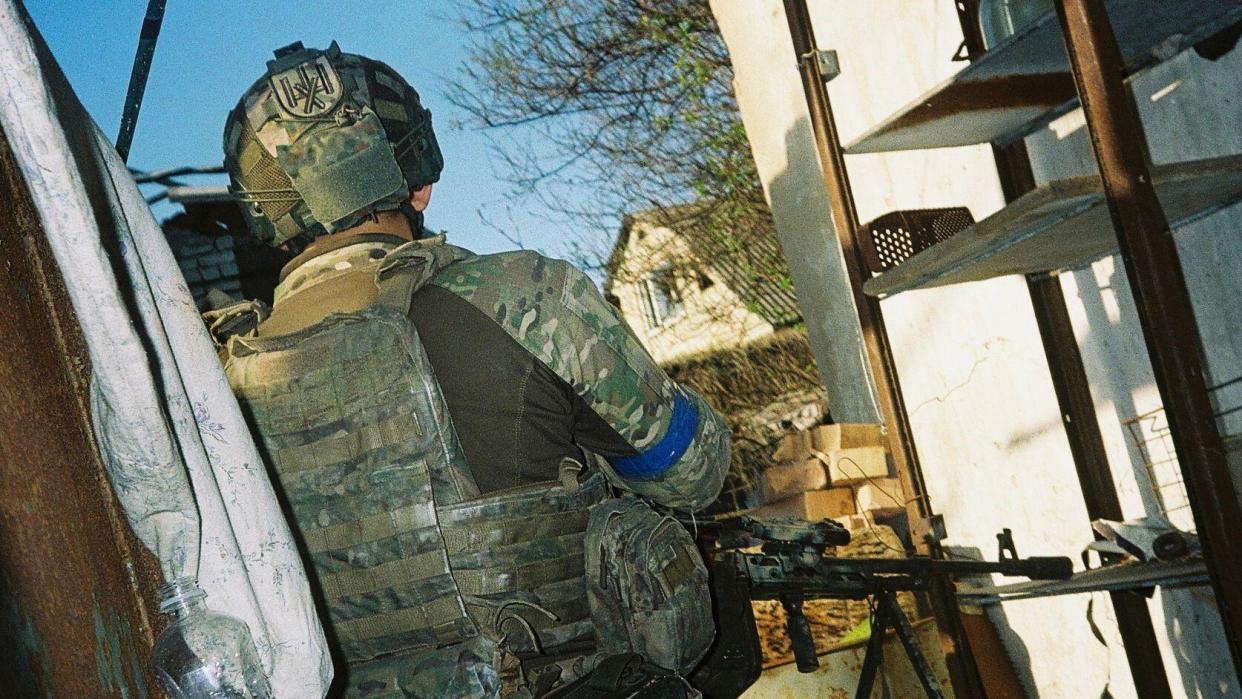 An untrained Ukrainian soldier stands outside, holding a gun