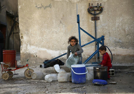 Children gather water in the besieged town of Douma, Eastern Ghouta, in Damascus, Syria March 11, 2018. REUTERS/ Bassam Khabieh